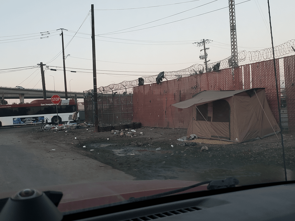 20241205_164458 A image of a single makeshift shelter, isolated against a fence